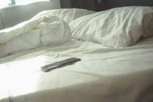smartphone on an unmade bed