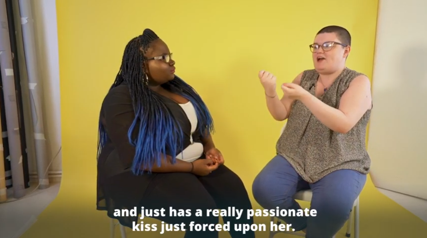 two people sit facing each other and talk in front of a yellow background