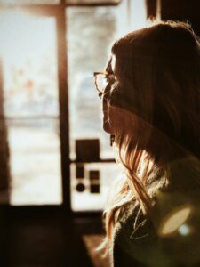 A woman staring out of a window thinking