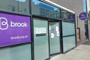 Entrance to Brook Manchester - blurred windows and large purple Brook logo by the main door