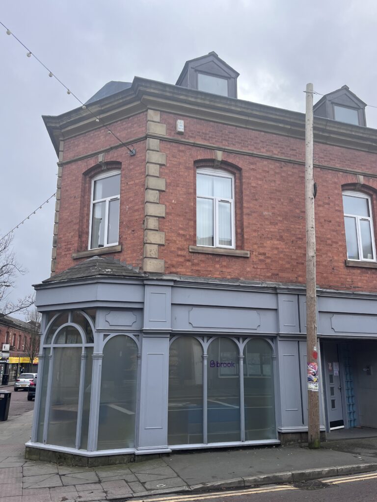 Brook Blackburn entrance. Grey entrance on ground floor of brick building