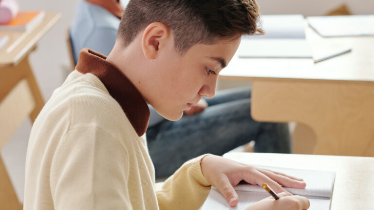 a boy in school writing something down