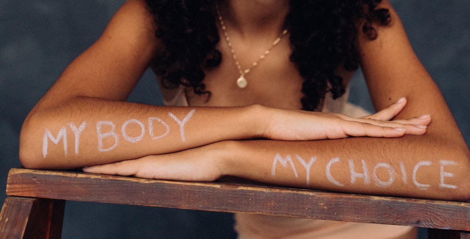 person's arms with 'my body my choice' painted on them