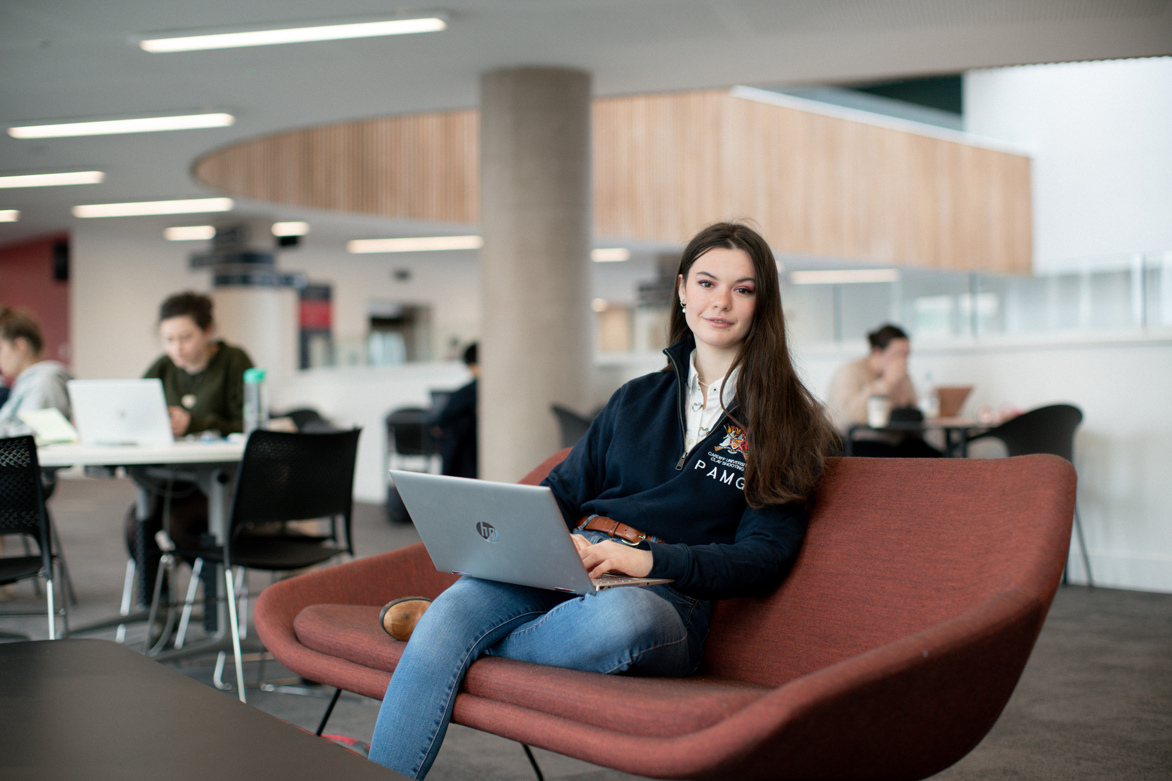 Person sitting with a laptop in a busy public place