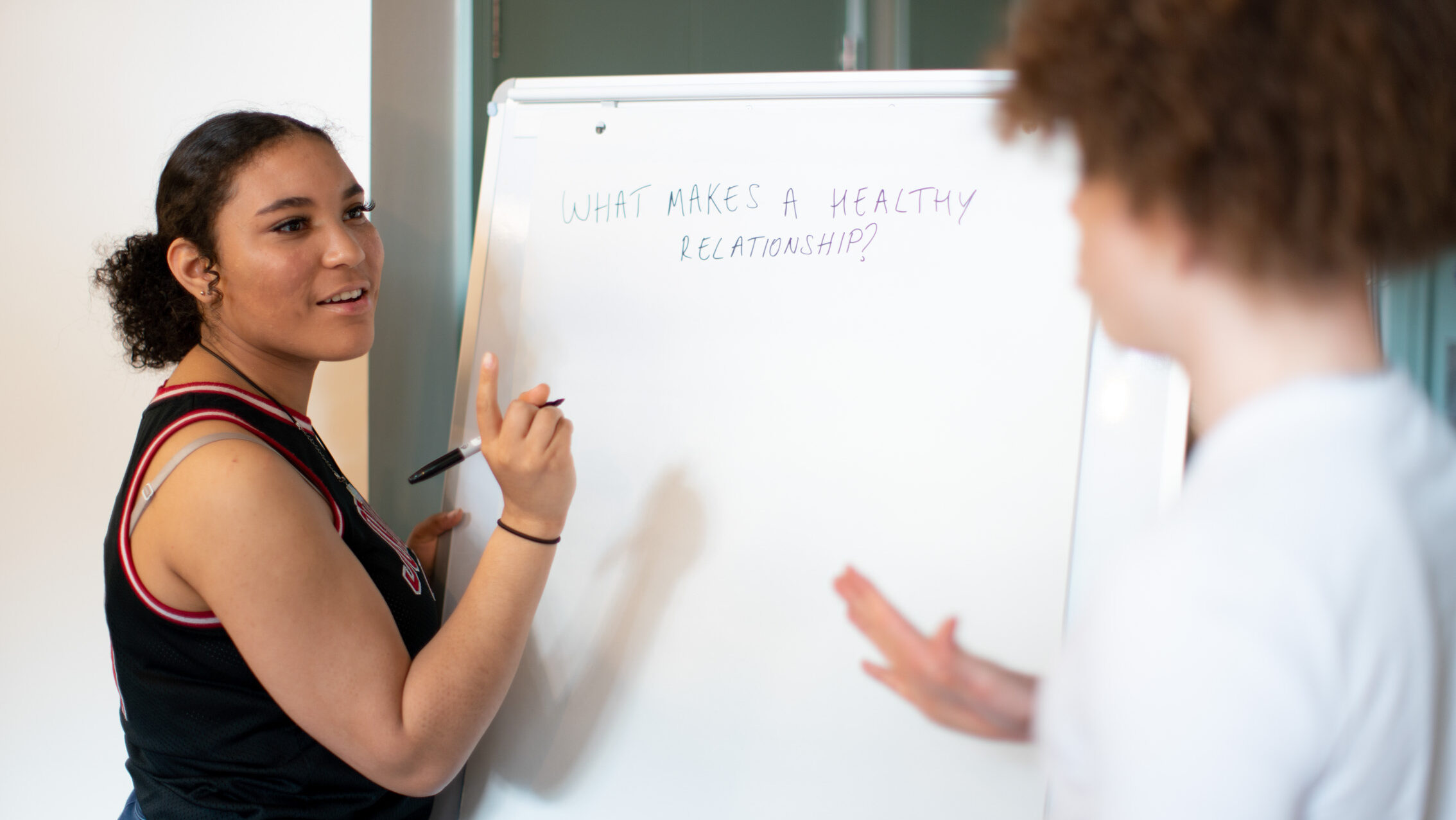 Two young people writing on a whiteboard