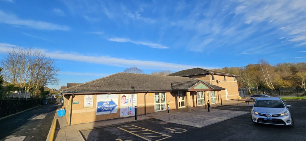 The Greens Medical Centre. A standalone building with a car park outside and a porch