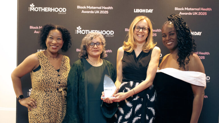 Four women posing for a photo at an award ceremony