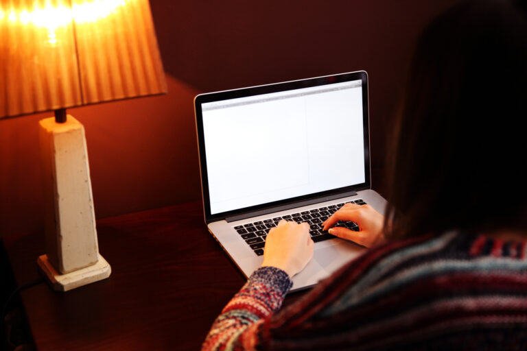 An over the shoulder photo of a woman using a laptop embedded in an article about online misogyny