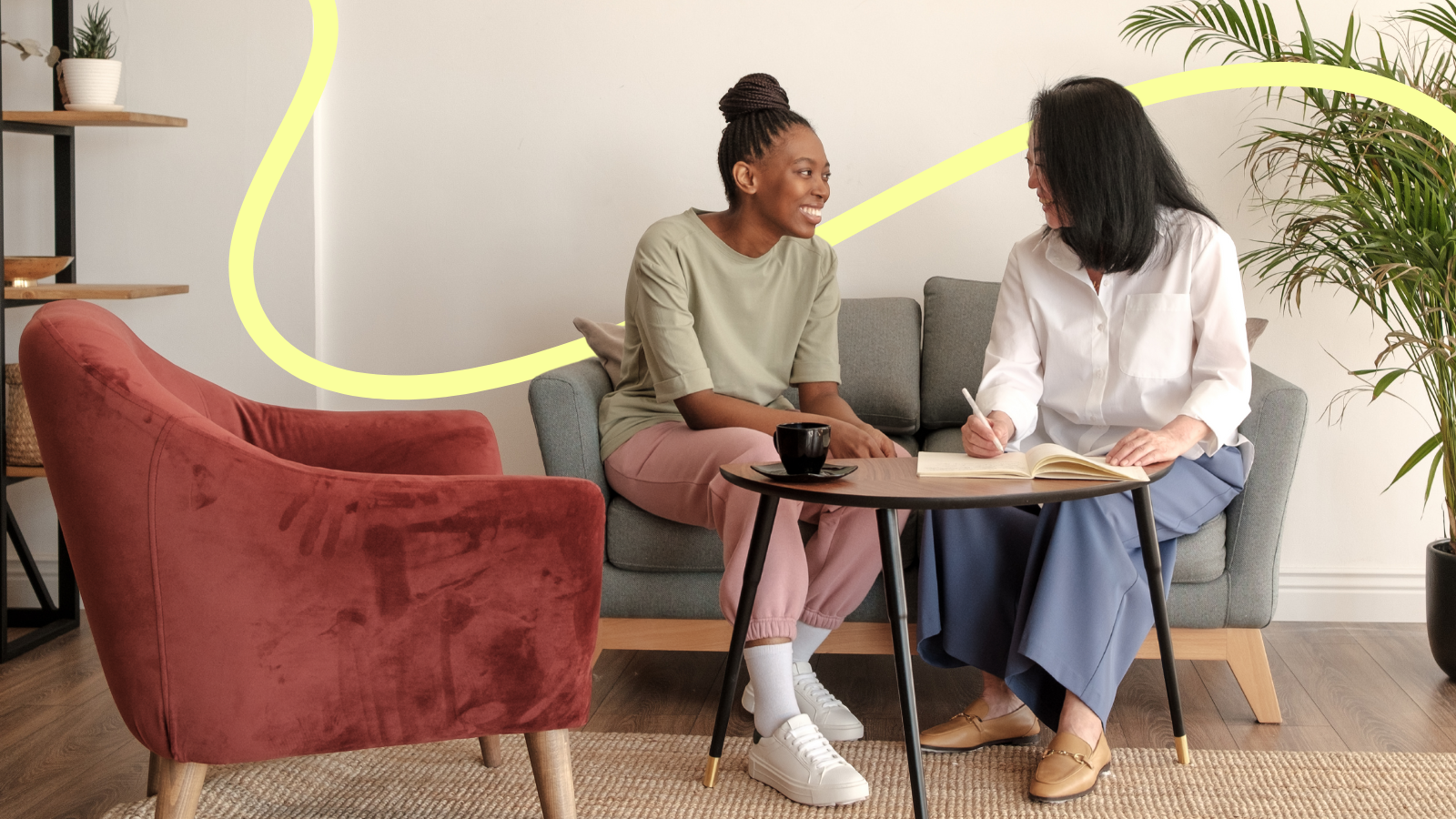 Two people at a counselling session sat on a sofa chatting