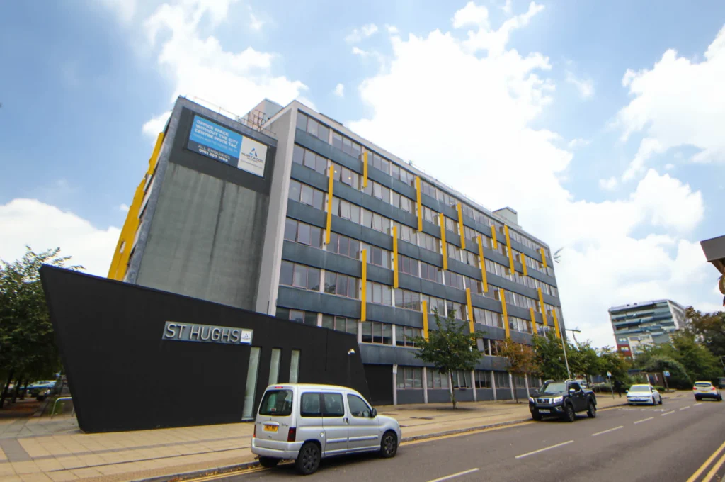 St Hugh's House Grey block building with yellow accents
