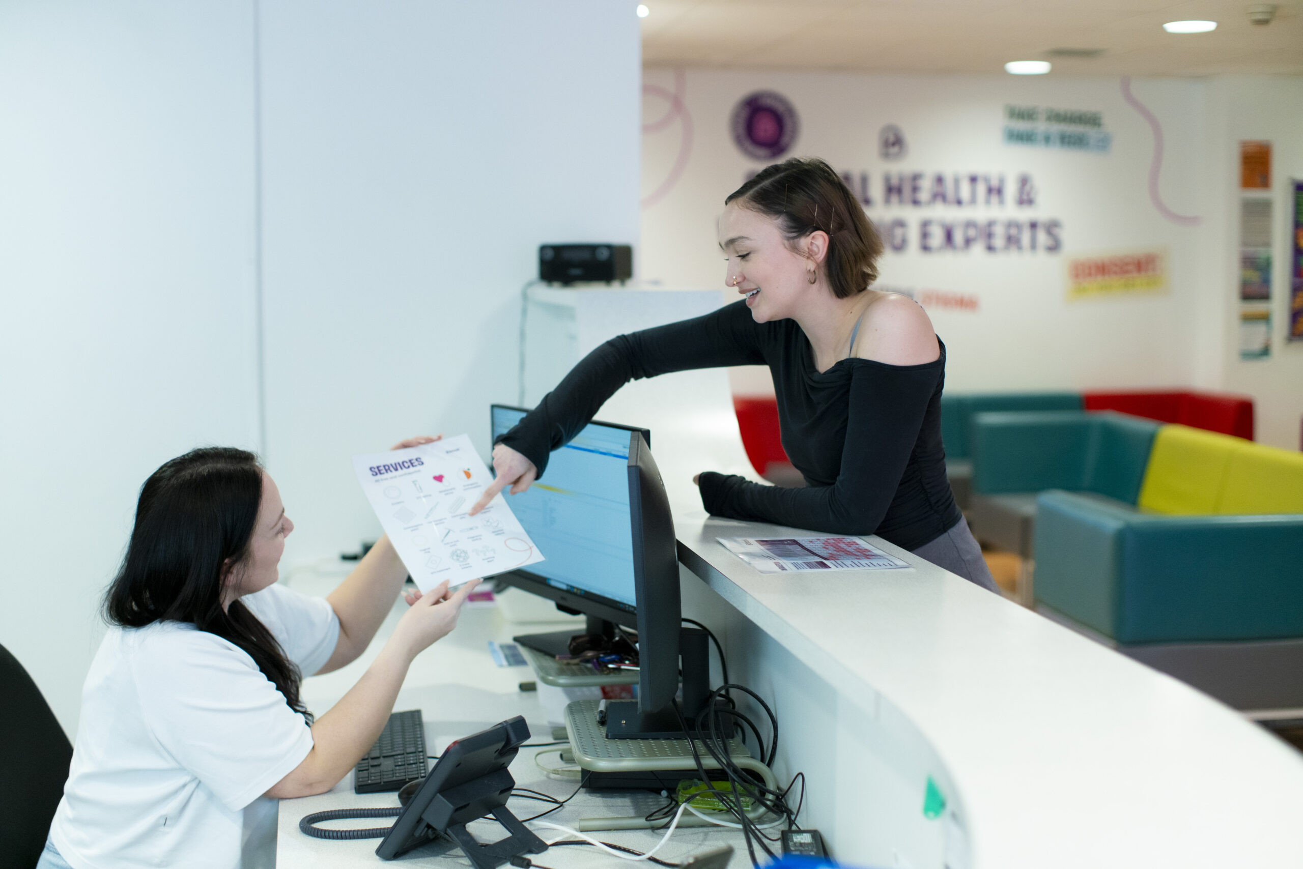 A patient at a Brook clinic points to an image on a piece of paper