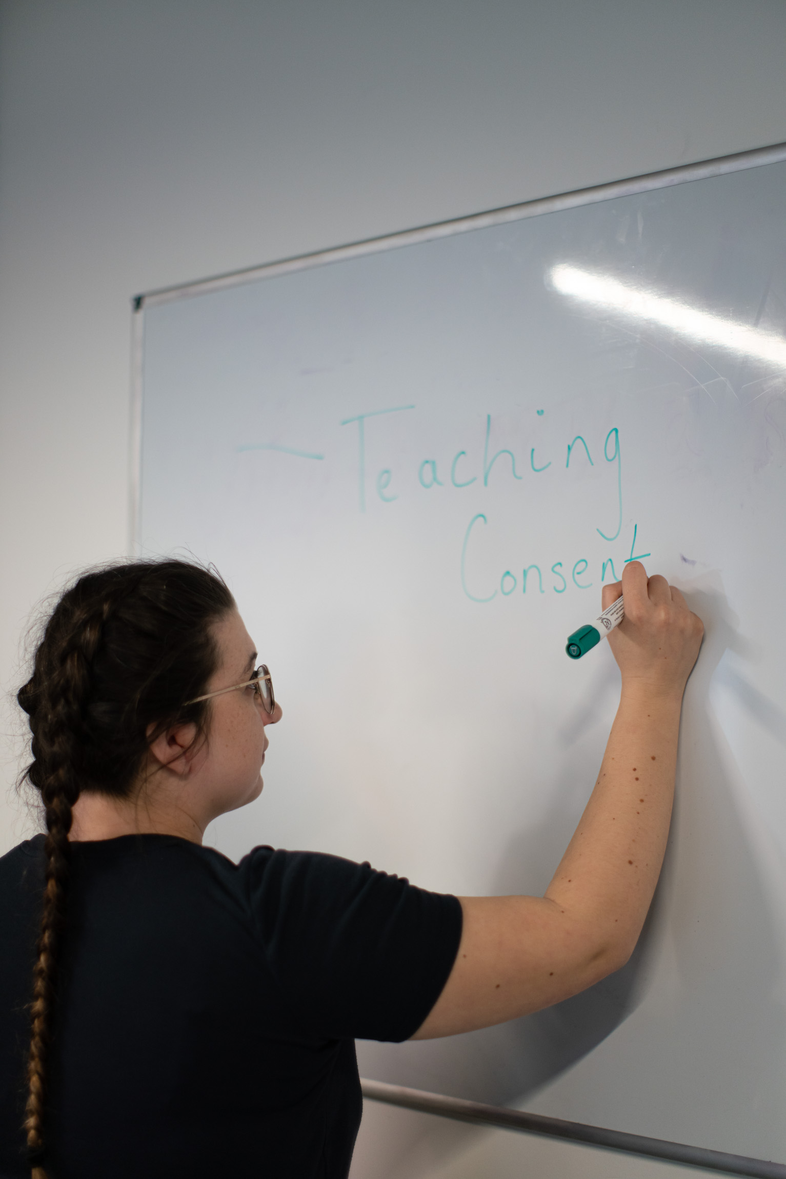 Education Specialist writing "Teaching consent" on the whiteboard