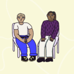 Two people sat on chairs, with one person upset