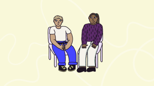 Two people sat on chairs, with one person upset