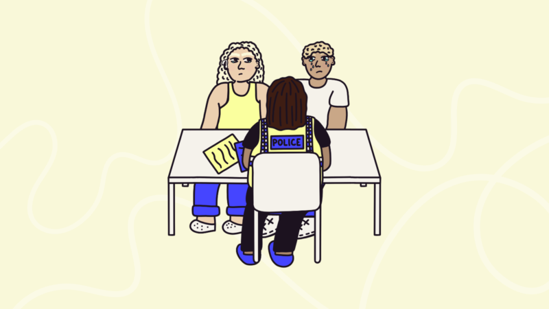 two people sat with a police officer