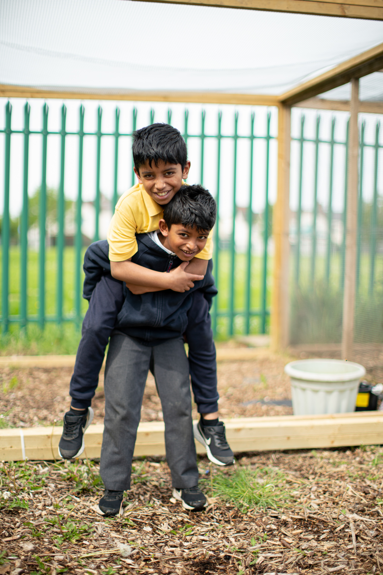 2 students playing in a garden