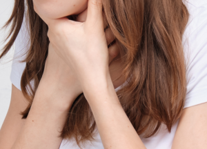 A person with hands around their neck