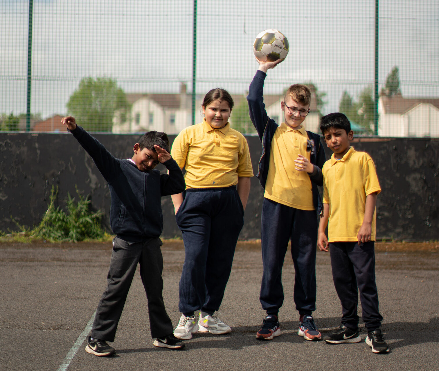 4 students standing in active oses on a school court