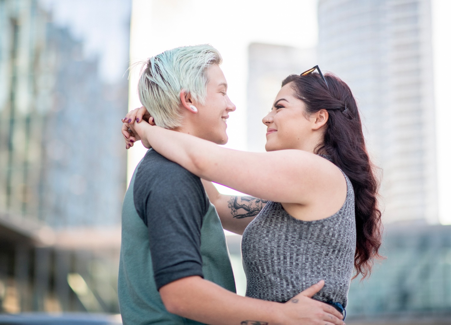 Two women smiling at each other, in an embrace